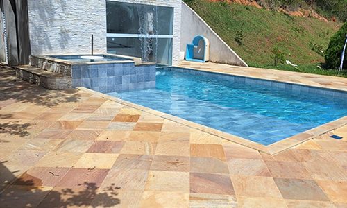 Piscina com spa e piso de pedra